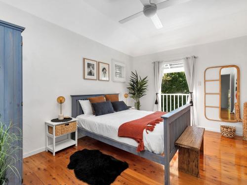 a bedroom with a bed with a ceiling fan at The Green Whaler Hyams Beach in Hyams Beach