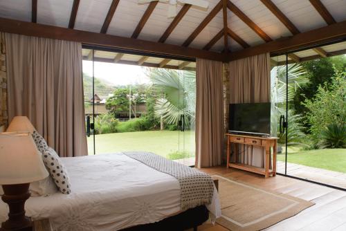 a bedroom with a bed and a flat screen tv at Pousada Boutique Itaipava in Itaipava