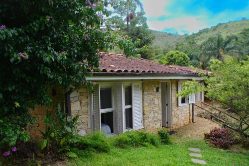 a small stone house in the middle of a yard at Pousada Boutique Itaipava in Itaipava