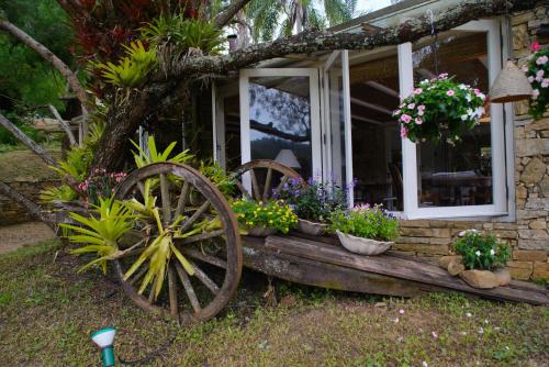 a house with a window with pots of flowers at Pousada Boutique Itaipava in Itaipava