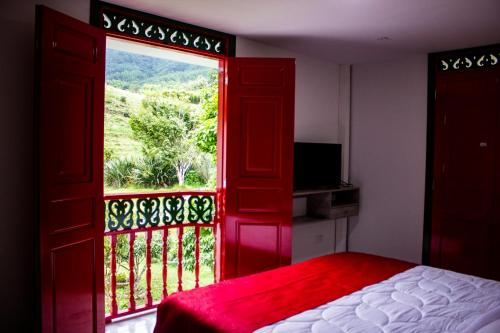 a bedroom with a red door and a window with a view at El Edén hotel Campestre in Pensilvania