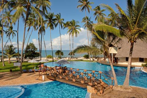 einen Pool im Resort mit Palmen in der Unterkunft Ocean Paradise Resort & Spa in Pwani Mchangani