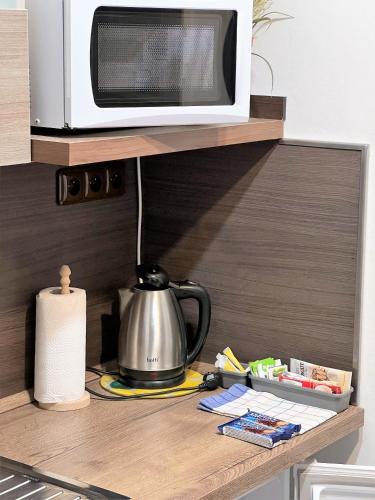Un microondas y una tetera en un estante en Apartmány Karlovy Vary, en Karlovy Vary