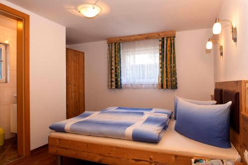 1 dormitorio con cama con sábanas azules y ventana en Alpenchalet Mitterlechner, en Bad Hofgastein