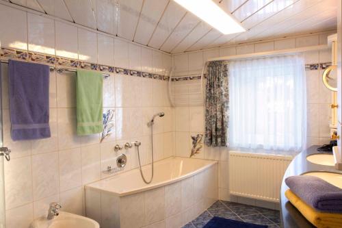 a bathroom with a tub and a shower and a sink at Alpenchalet Mitterlechner in Bad Hofgastein