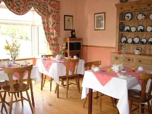 un comedor con mesas y sillas y una ventana en Quarry Ridge B&B, en Carlow