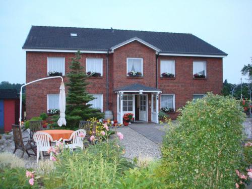 a red brick house with a table and chairs at Ferienhaus Tobie in Ahlefeld