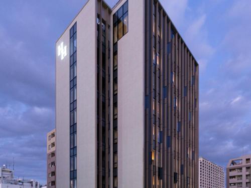 a tall building with a sign on the side of it at Akabane Holic Hotel in Tokyo