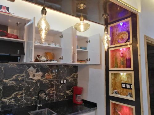 une cuisine avec des armoires blanches et des lumières dans l'établissement Ryan 1, à Fès