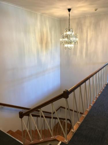 a staircase with a chandelier in a building at Myrtleford Hotel in Myrtleford