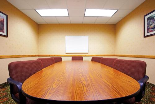 uma sala de conferências com uma mesa de madeira e cadeiras em Candlewood Suites Grand Rapids Airport, an IHG Hotel em Grand Rapids