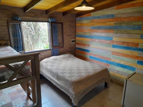 1 dormitorio con 1 cama y una pared colorida en EL ZORZAL Dormis con Galeria en Villa del Dique