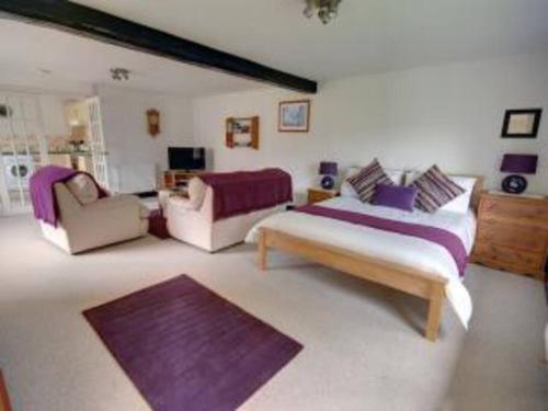 a large bedroom with a bed and a couch and a couch at Priory Cottage, North Devon in Barnstaple