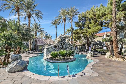 una piscina en un complejo con palmeras en Condo close to Strip and Raiders Stadium, en Las Vegas