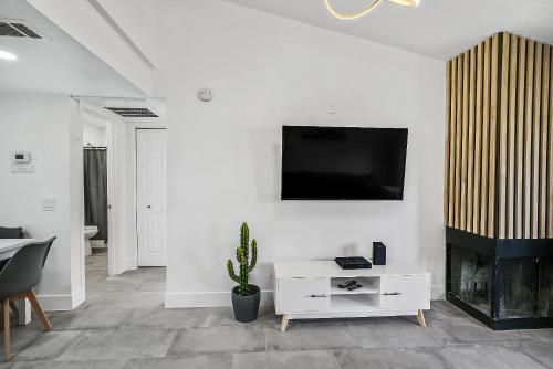 a living room with a tv on a white wall at Condo close to Strip and Raiders Stadium in Las Vegas