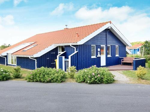 a blue house with a bench in front of it at 12 person holiday home in Otterndorf in Otterndorf