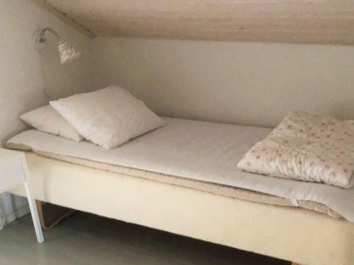 a bed in a small room with two pillows on it at 5 person holiday home in KUNGSHAMN-By Traum in Hovenäset