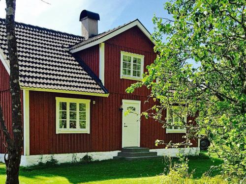 a red house with a white door at 6 person holiday home in Vittsj in Ubbalt