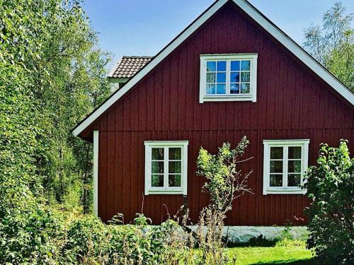 a red house with a white window on the side of it at 6 person holiday home in Vittsj in Ubbalt