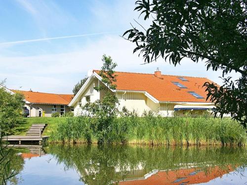 オッテルンドルフにある12 person holiday home in Otterndorfの川の横のオレンジの屋根の家