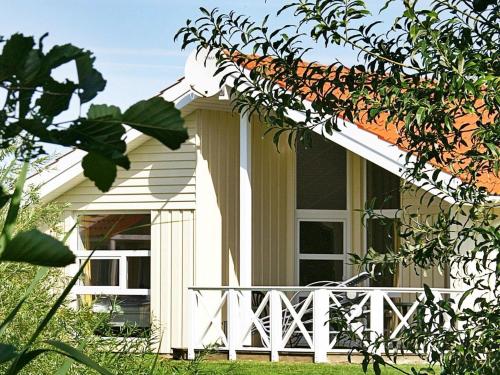 ein Haus mit einer weißen Veranda und einem Fenster in der Unterkunft 12 person holiday home in Otterndorf in Otterndorf