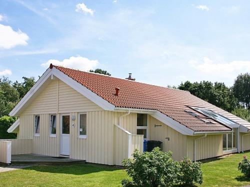 a small white house with a red roof at 12 person holiday home in Otterndorf in Otterndorf