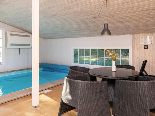 a dining room with a pool and a table and chairs at 8 person holiday home in Ringk bing in Klegod
