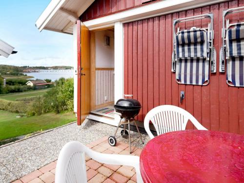 ハンブルクスンドにある4 person holiday home in Hamburgsundの赤い家(テーブル、椅子、グリル付)