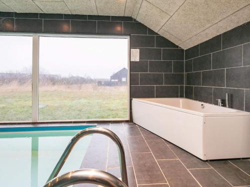 baño grande con bañera y piscina en Ten-Bedroom Holiday home in Brovst, en Brovst