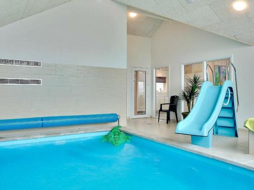 a swimming pool with a blue slide in a room at 16 person holiday home in Tisvildeleje in Tisvildeleje