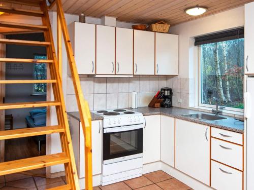 a kitchen with white cabinets and a ladder at 6 person holiday home in Kib k in Skarrild