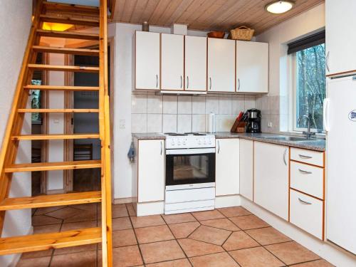 a kitchen with white cabinets and a ladder at 6 person holiday home in Kib k in Skarrild