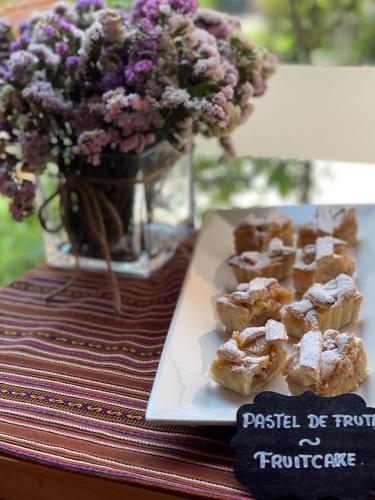 a plate of pastries on a table with a vase of flowers at Union Hotel Cusco in Cusco