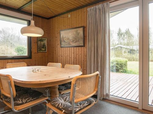 a dining room with a wooden table and chairs at 6 person holiday home in Toftlund-By Traum in Vestergård