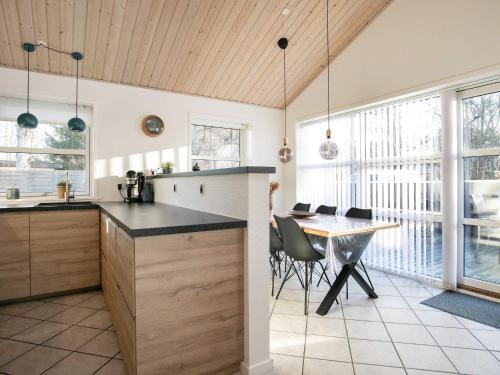 a kitchen and dining room with a table and chairs at 8 person holiday home in L s in Læsø