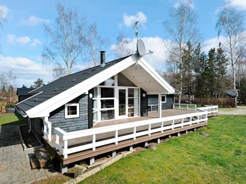 una pequeña casa con un satélite en el techo en 10 person holiday home in F rvang, en Fårvang