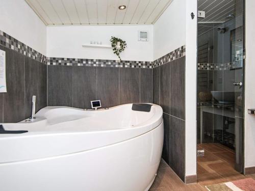 a white bath tub in a bathroom with tile walls at 5 person holiday home in Hemmet in Falen