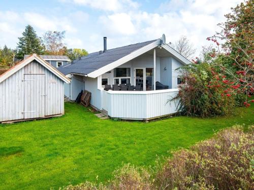 a white house with a yard at 8 person holiday home in Juelsminde in Sønderby