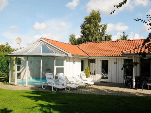 a house with chairs and a swimming pool at 8 person holiday home in Juelsminde in Sønderby