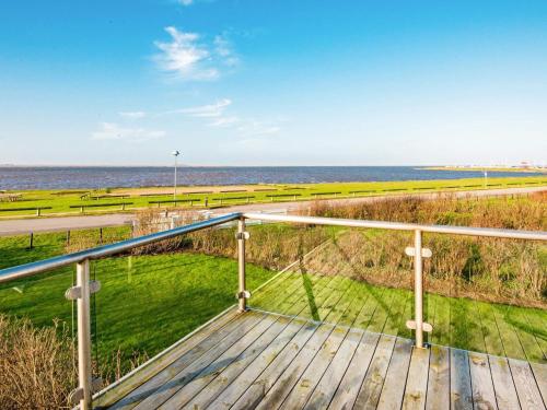 a balcony with a view of the ocean and a boardwalk at 7 person holiday home in Hemmet in Falen