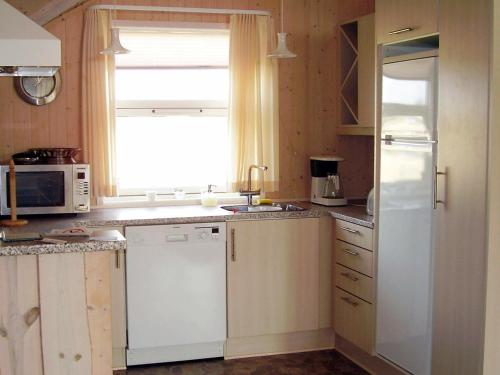 a kitchen with a white refrigerator and a window at 5 person holiday home in R dby in Kramnitse