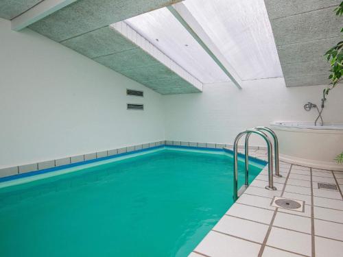 een zwembad met een bad en een bad bij 14 person holiday home in rsted in Kare
