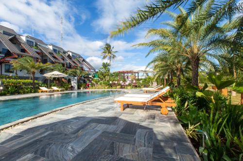 una piscina en un complejo con un banco y palmeras en Hami Garden - Authentic & Natural Resort en Buôn Ju