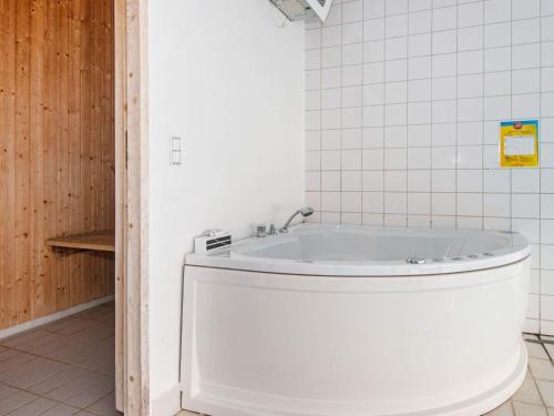 エーベルトフトにあるFive-Bedroom Holiday home in Ebeltoft 3の白いタイル張りのバスルーム(バスタブ付)