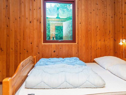 VestergårdにあるThree-Bedroom Holiday home in Toftlund 32の木製の壁のベッドルーム1室