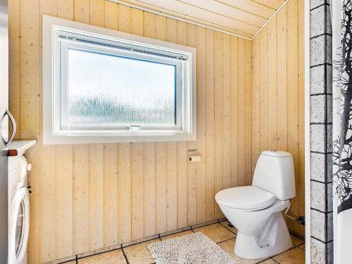 a bathroom with a toilet and a window at Stylish Beach House - By Traum Ferienwohnungen in Nordborg