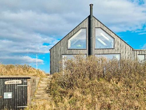 バイアス・スタンにある6 person holiday home in Vejers Strandの木造家屋(丘の上に大きな窓あり)