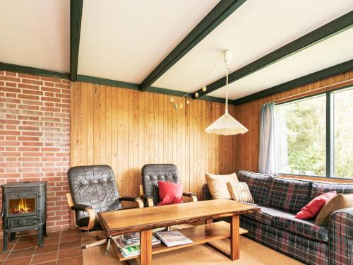 sala de estar con sofá, mesa y chimenea en 5 person holiday home in H jslev, en Bøstrup