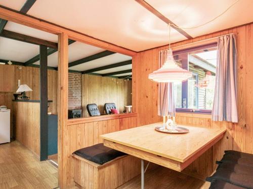 a dining room with a wooden table and a window at 5 person holiday home in H jslev in Bøstrup
