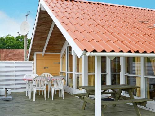 Hemmetにある8 person holiday home in Hemmetの白い椅子とオレンジ色の屋根のポーチ